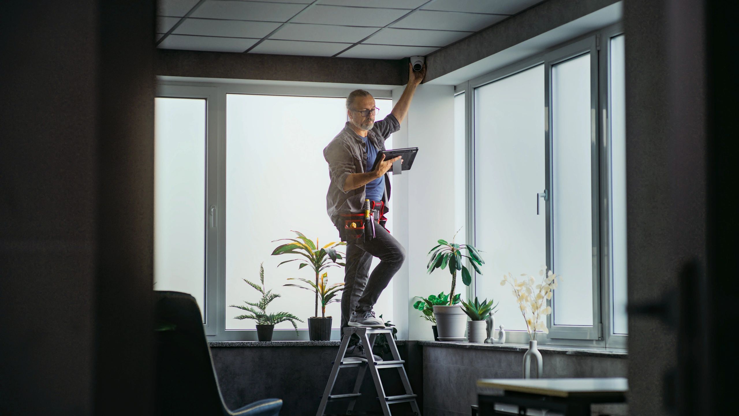 Technician installing CCTV camera using tablet